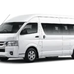 Toyota Hiace Commuter putih tampak serong depan dan samping untuk layanan sewa Hiace Jakarta dengan driver profesional